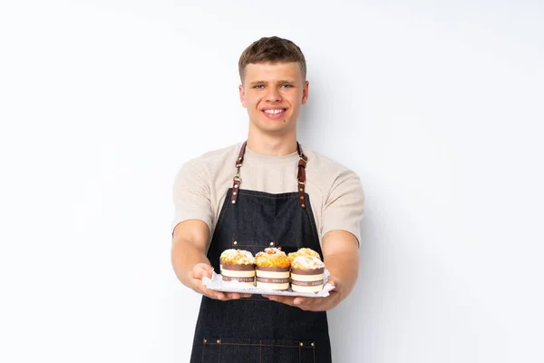 Junge Hübsche Mann Über Isolierten Weißen Hintergrund Hält Mini Kuchen — Stockfoto