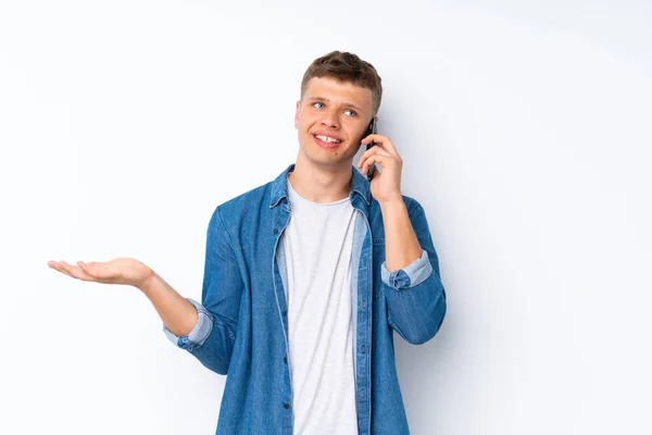 Fiatal Jóképű Férfi Elszigetelt Fehér Háttér Miközben Egy Beszélgetést Mobiltelefon — Stock Fotó