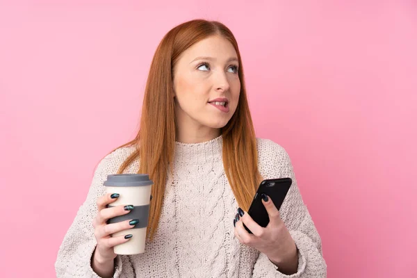 Giovane Donna Rossa Sfondo Rosa Isolato Che Tiene Caffè Portare — Foto Stock