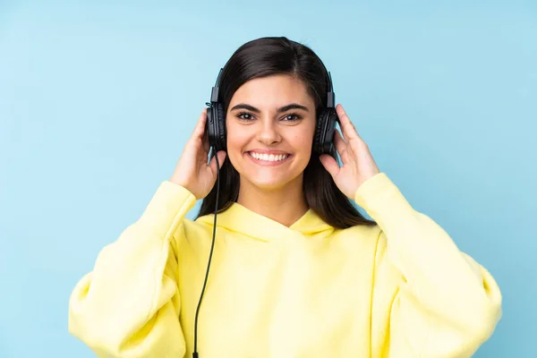 Mujer Joven Sobre Fondo Azul Aislado Escuchando Música —  Fotos de Stock