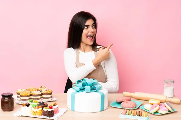 Konditor Mit Einem Großen Kuchen Einem Tisch Über Isoliertem Rosa — Stockfoto