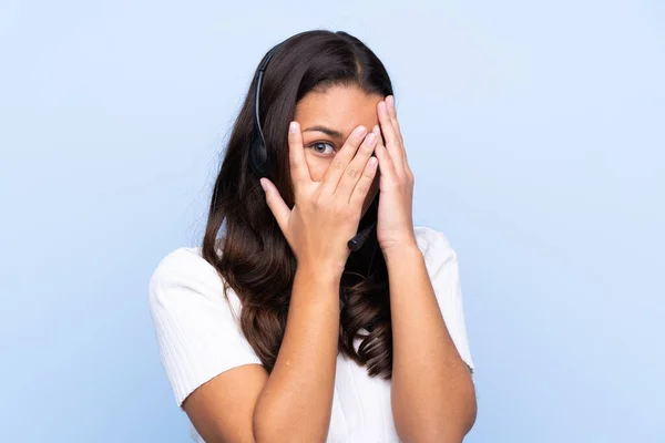 Jovem Telemarketer Mulher Colombiana Sobre Fundo Azul Isolado Cobrindo Olhos — Fotografia de Stock