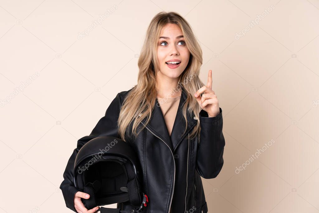 Russian girl with a motorcycle helmet isolated on beige background intending to realizes the solution while lifting a finger up