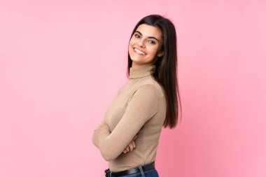 Kollarını kavuşturup ileriye bakan pembe bir geçmişi olan genç bir kadın.