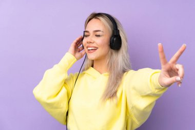 Mor arka planda müzik dinleyen ve şarkı söyleyen genç bir kız.