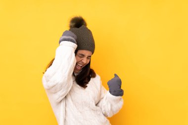 Sarı arka planda, sarı şapkalı genç bir kadın zaferi kutluyor.