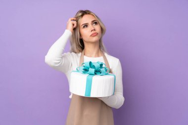 Genç pasta şefi mor arka planda büyük bir pasta tutuyor. Şüpheleri var ve kafası karışık.