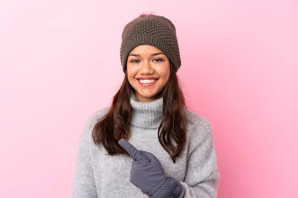Young Colombian Girl Winter Hat Isolated Pink Wall Pointing Finger — Stock Photo, Image