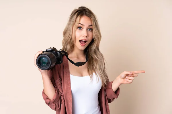 Jovem Fotógrafo Menina Sobre Fundo Isolado Surpreendido Apontando Lado — Fotografia de Stock