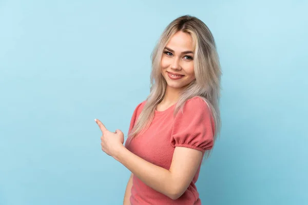 Adolescente Chica Sobre Aislado Azul Fondo Apuntando Hacia Atrás — Foto de Stock