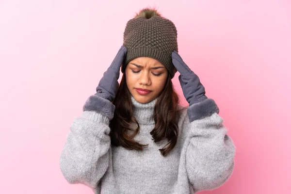 孤立したピンクの壁の上に冬の帽子をかぶった若いコロンビア人の女の子が不幸で何かに不満 否定的な表情 — ストック写真