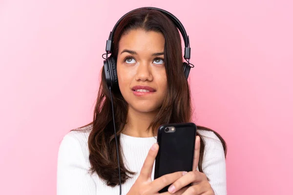 Νεαρή Γυναίκα Ακουστικά Πάνω Από Απομονωμένο Ροζ Τοίχο — Φωτογραφία Αρχείου