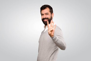 Yakışıklı adam mutlu ve gri arka planda parmakları olan dört kişi sayıyor.