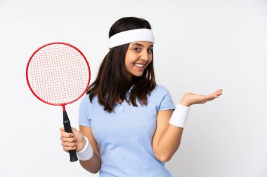 İzole edilmiş beyaz arkaplan üzerinde genç badminton oyuncusu kadın bir reklam eklemek için avucunda hayali bir metin tutuyor.