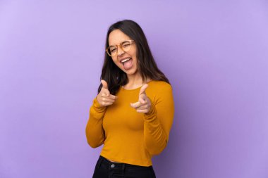 Mor arka planda izole edilmiş genç bir ırk kadını ön tarafı gösteriyor ve gülümsüyor.