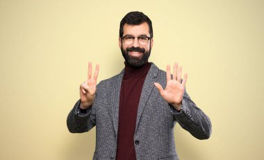 Gözlüklü yakışıklı adam yediyi parmaklarıyla sayıyor.