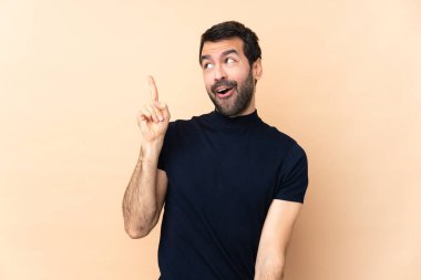 Kafkasyalı yakışıklı adam izole edilmiş arka planda çözümü bulmak için parmağını kaldırıyor.