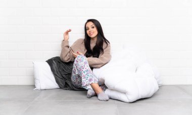 İçerde pijamalı genç Kolombiyalı kız içeri davet edildiği için ellerini yana açıyor.