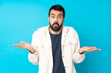 Mavi arka planda beyaz kadife ceketli genç yakışıklı şüpheli hareketler yapıyor.