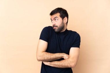 Kafkasyalı yakışıklı adam, izole edilmiş arka planda. Omuzlarını kaldırırken şüpheyle hareket ediyor.