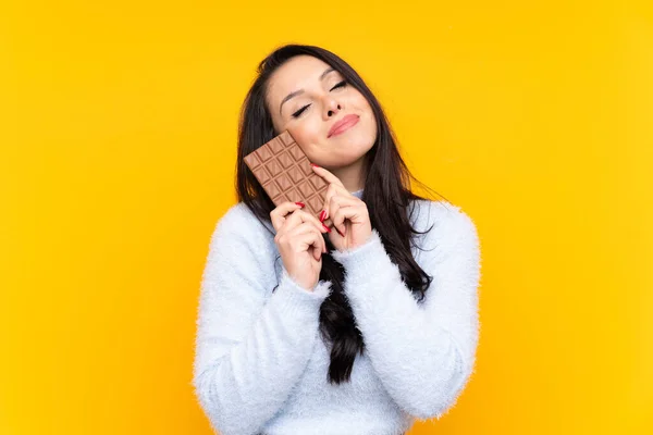 Mladá Kolumbijská Dívka Přes Izolované Žluté Pozadí Čokoládovou Tabletu Šťastný — Stock fotografie