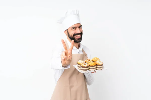 Joven Sosteniendo Pastel Magdalenas Sobre Fondo Blanco Aislado Sonriendo Mostrando — Foto de Stock