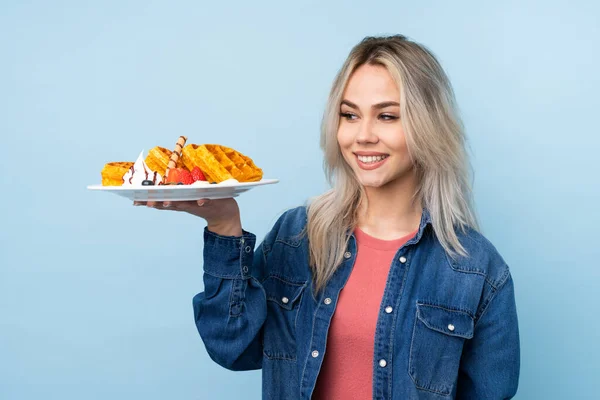 Tiener Meisje Houden Wafels Geïsoleerde Blauwe Achtergrond Met Gelukkige Expressie — Stockfoto