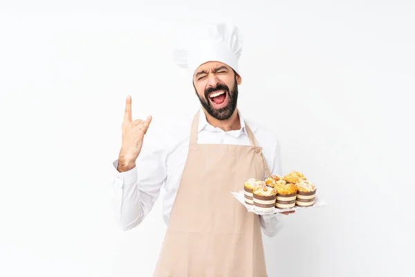 Jongeman Houdt Muffin Cake Geïsoleerde Witte Achtergrond Maken Rock Gebaar — Stockfoto