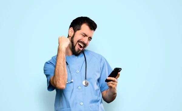 Chirurg Arts Man Met Telefoon Overwinningspositie Geïsoleerde Blauwe Achtergrond — Stockfoto
