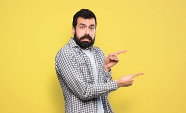 Sakallı yakışıklı adam korkmuş ve yüzünü gösteriyor.