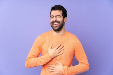 Kafkasyalı yakışıklı bir adam soyutlanmış mor arka planda gülümsüyor.