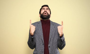 Gözlüklü yakışıklı adam şaşırmış ve işaret ediyor.