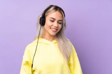 Soyutlanmış mor arka planda müzik dinleyen genç kız.