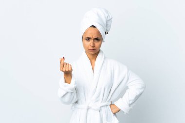 Bornozlu genç bir kadın soyutlanmış beyaz arka planda para jesti yapıyor ama mahvoluyor.