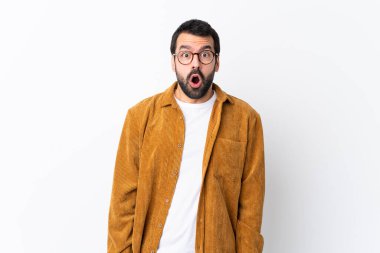 Beyaz arka plan üzerinde kadife ceket giyen, sakallı, beyaz yüzlü, şaşırtıcı bir yüz ifadesi olan beyaz tenli yakışıklı bir adam.