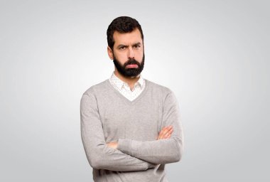 Gri arka planda üzgün ve depresif bir yüzü olan yakışıklı bir adam.