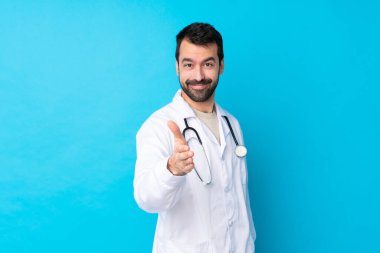 Kafkas kökenli genç bir adam doktor önlüğü giyiyor ve steteskopla anlaşma yapıyor.