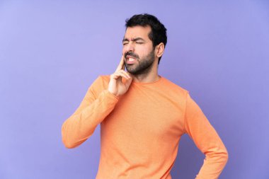 İzole edilmiş mor arka planı olan, diş ağrısı olan beyaz, yakışıklı bir adam.