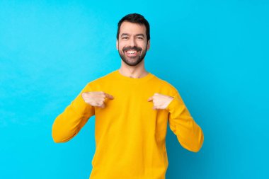 İzole edilmiş mavi arka planda, şaşırmış yüz ifadesi olan genç beyaz bir adam.