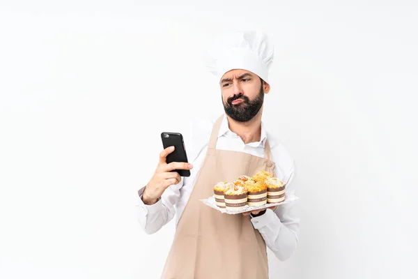 Jongeman Houdt Muffin Cake Geïsoleerde Witte Achtergrond Denken Het Verzenden — Stockfoto