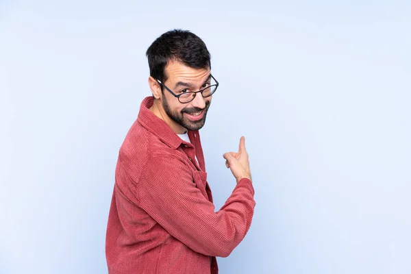 Young Caucasian Man Wearing Corduroy Jacket Blue Background Pointing Back — Stock Photo, Image