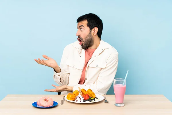 Mannen Vid Ett Bord Med Frukostvåfflor Och Milkshake Med Överraskande — Stockfoto