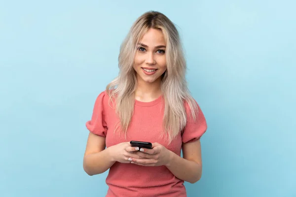 Tini Lány Elszigetelt Kék Háttér Küld Egy Üzenetet Mobil — Stock Fotó