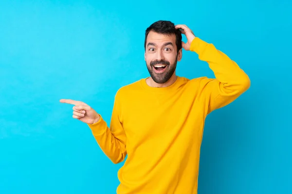 Young Caucasian Man Isolated Blue Background Surprised Pointing Finger Side — Stock Photo, Image