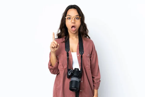 指を持ち上げながら解決策を実現しようとする孤立した白い背景の上に若い写真家の女性 — ストック写真
