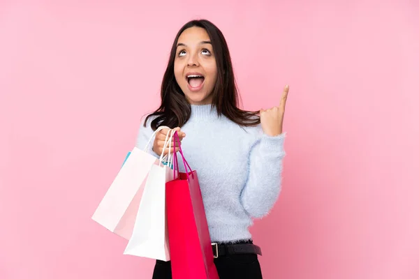 Ung Kvinna Med Shoppingväska Över Isolerad Rosa Bakgrund Pekar Upp — Stockfoto