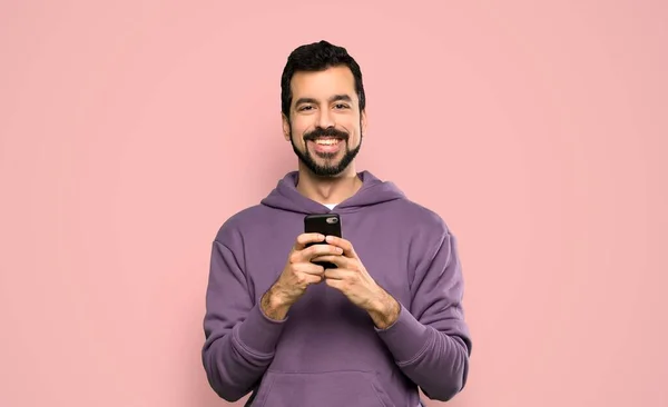 Schöner Mann Mit Sweatshirt Sendet Eine Nachricht Mit Dem Handy — Stockfoto