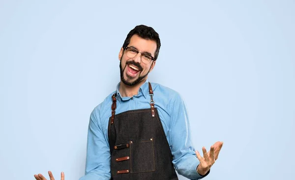 Hombre Con Delantal Sonriendo Sobre Fondo Azul Aislado — Foto de Stock