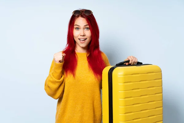 Chica Viajera Sosteniendo Una Maleta Aislada Sobre Fondo Azul Celebrando — Foto de Stock