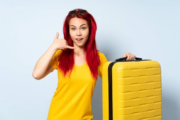 Ragazza Viaggiatore Possesso Una Valigia Isolata Sfondo Blu Facendo Gesto — Foto Stock